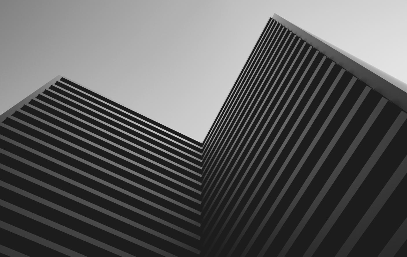Fotografia artística contemporânea em preto e branco de um prédio visto de baixo pra cima