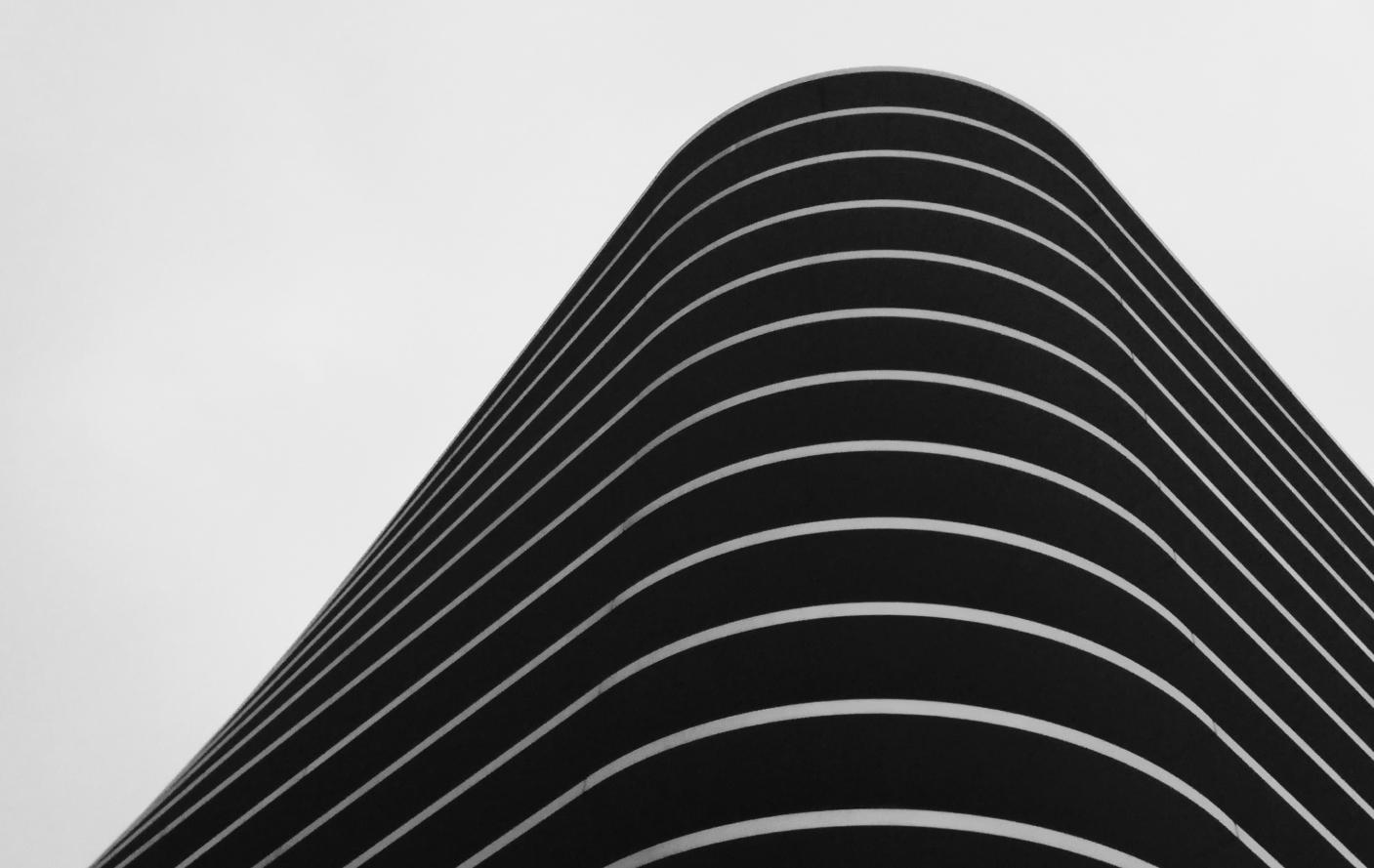 Arte abstrata em preto em branco com ondas que remetem a visão de um edifício contemporâneo visto de baixo para cima