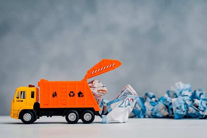 Caminhão de lixo de brinquedo carregando dinheiro e reserva de emergência onde investir