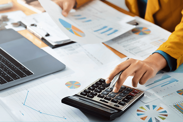 Mulher com calculadora fazendo conta da rentabilidade real dos investimentos