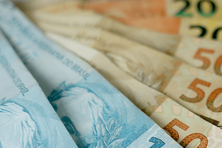A imagem mostra notas de cem, cinquenta e vinte reais dispostas umas sobre as outras. Selic e inflação.