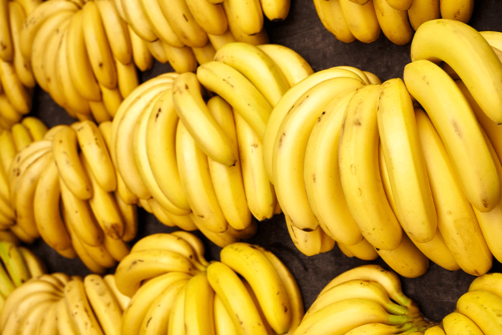 Cachos de bananas dispostos numa tábua de madeira. Selic e inflação.